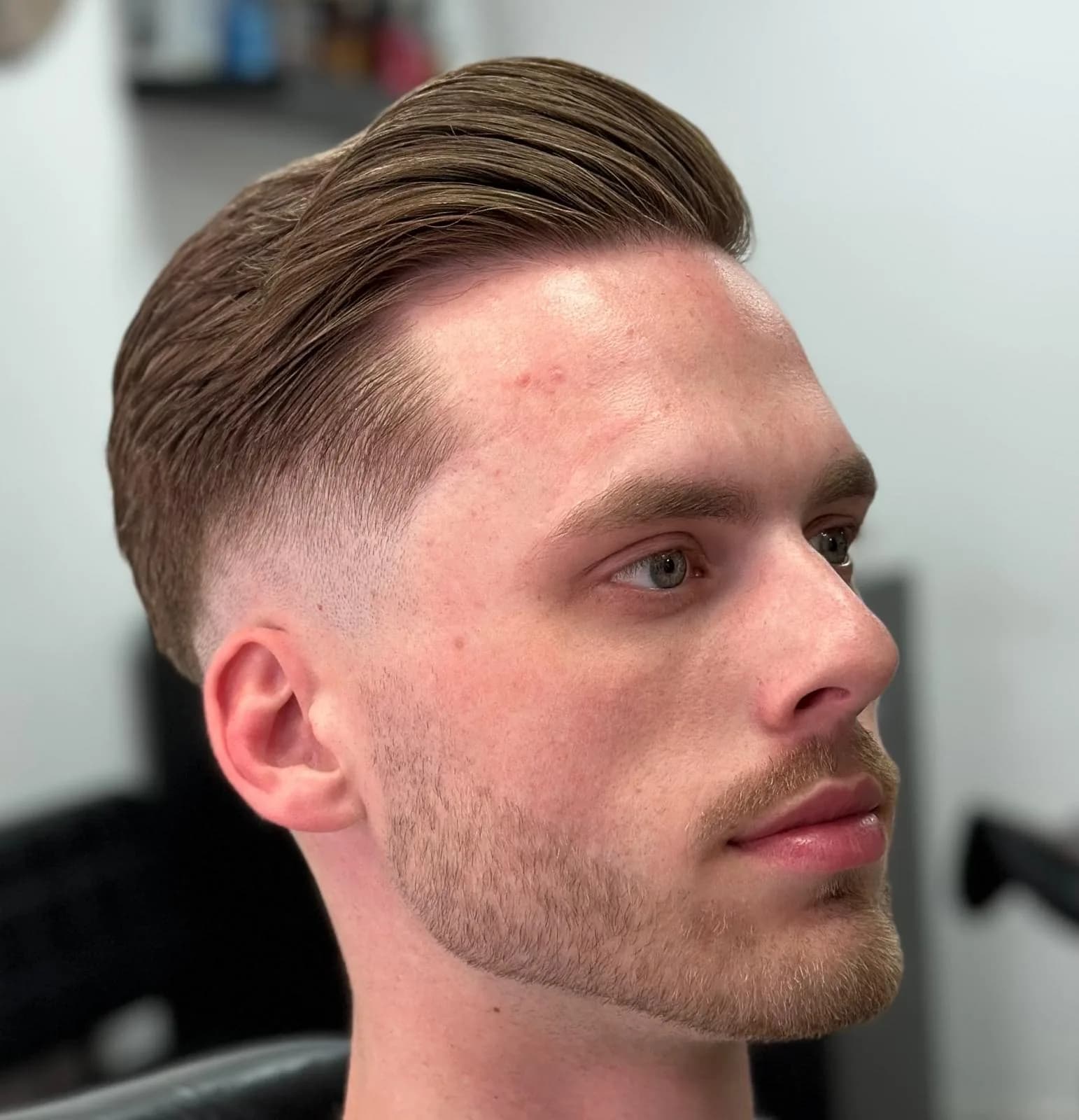Klassieke coupe met zijscheiding en lage fade bij Barbershop De Maten in Apeldoorn