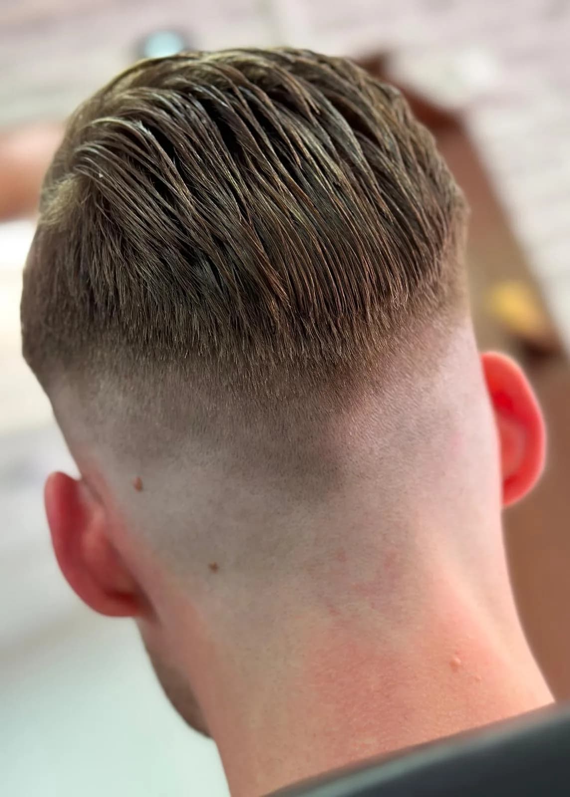 Klassiek grijs herenkapsel met moderne afwerking bij Barbershop De Maten