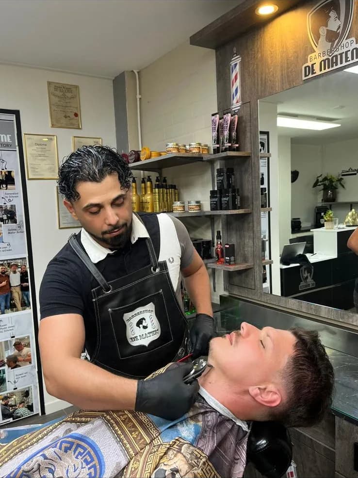Klant wordt met zorg geholpen bij Barbershop De Maten